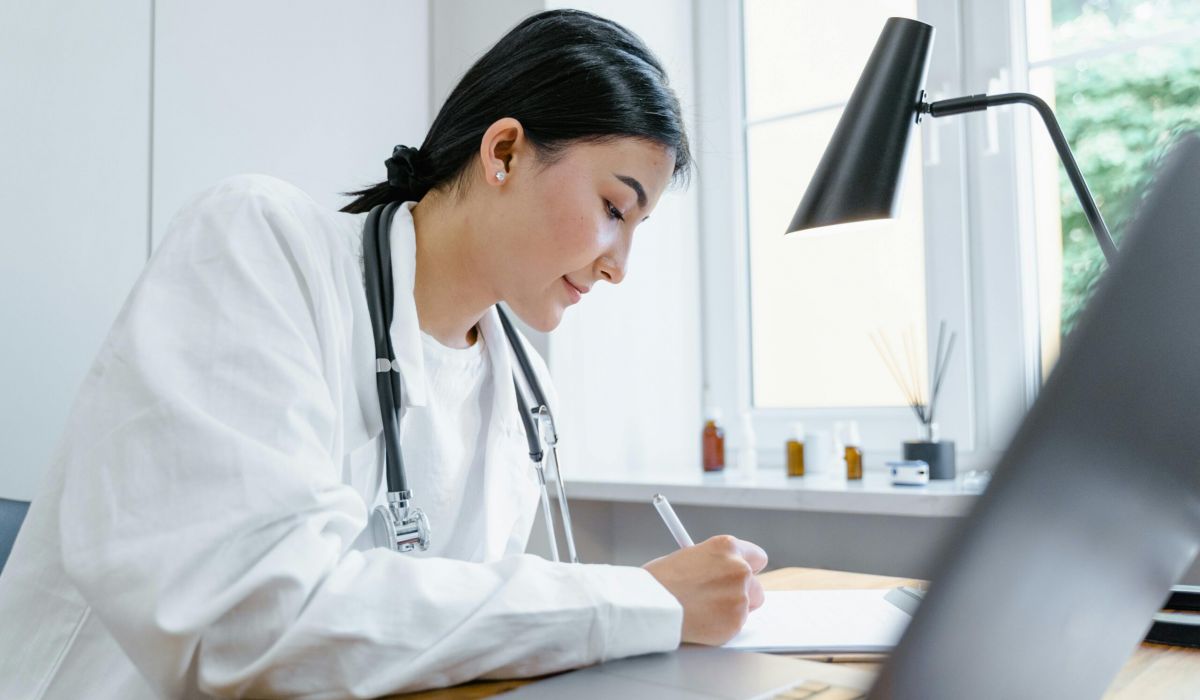Healthcare compliance professional reviewing audit documentation at her desk