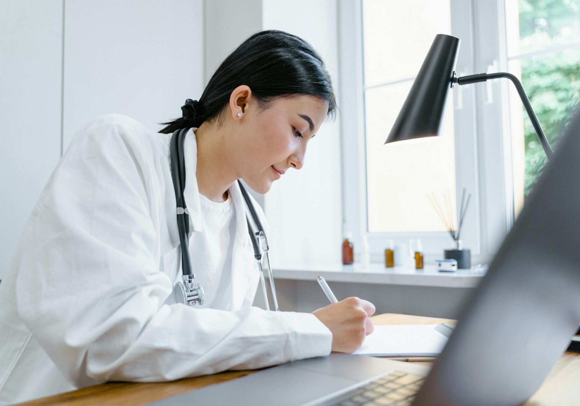 Healthcare compliance professional reviewing audit documentation at her desk